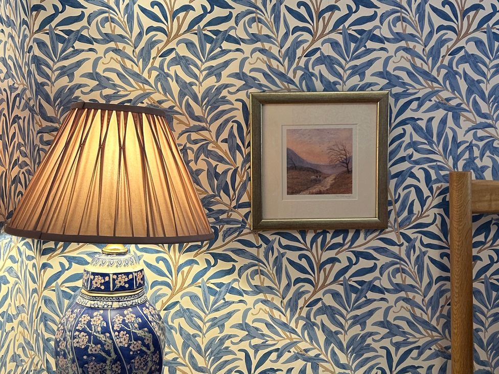 A lamp and framed picture on a wall at Tarn House in Hawes