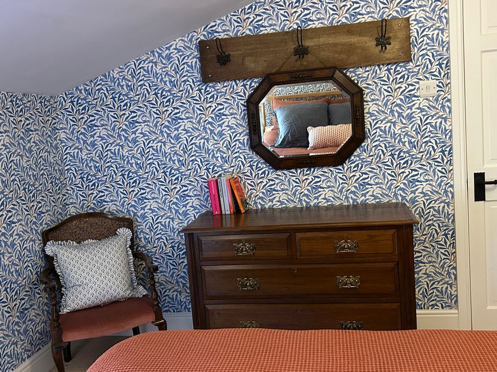 A bedroom with a dresser and a mirror at Tarn House in Hawes