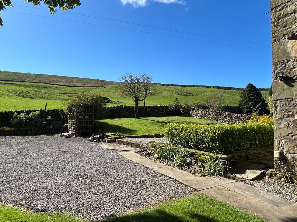 A garden with a tree and gravel path at Tarn House in Hawes