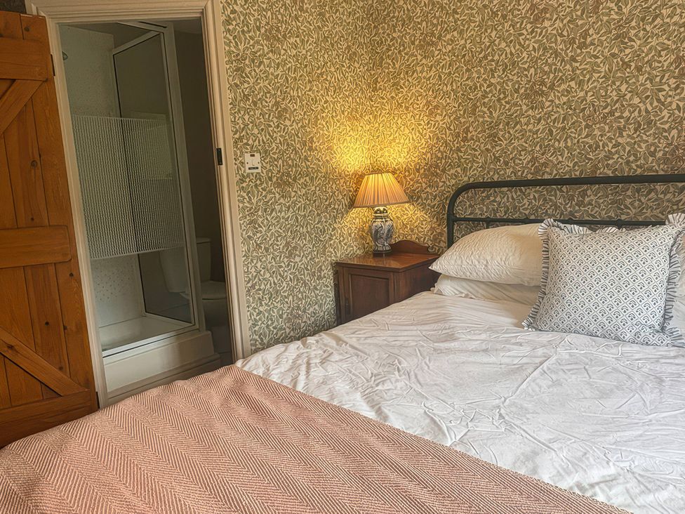 A bedroom with a bed and shower enclosure at Tarn House in Hawes