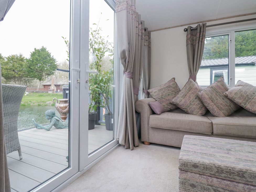 A living room with a sofa and glass doors at Carp Lodge