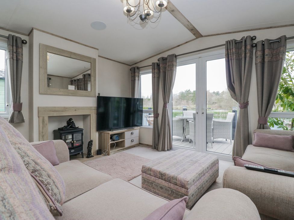 A living room with a sofa and television at Carp Lodge