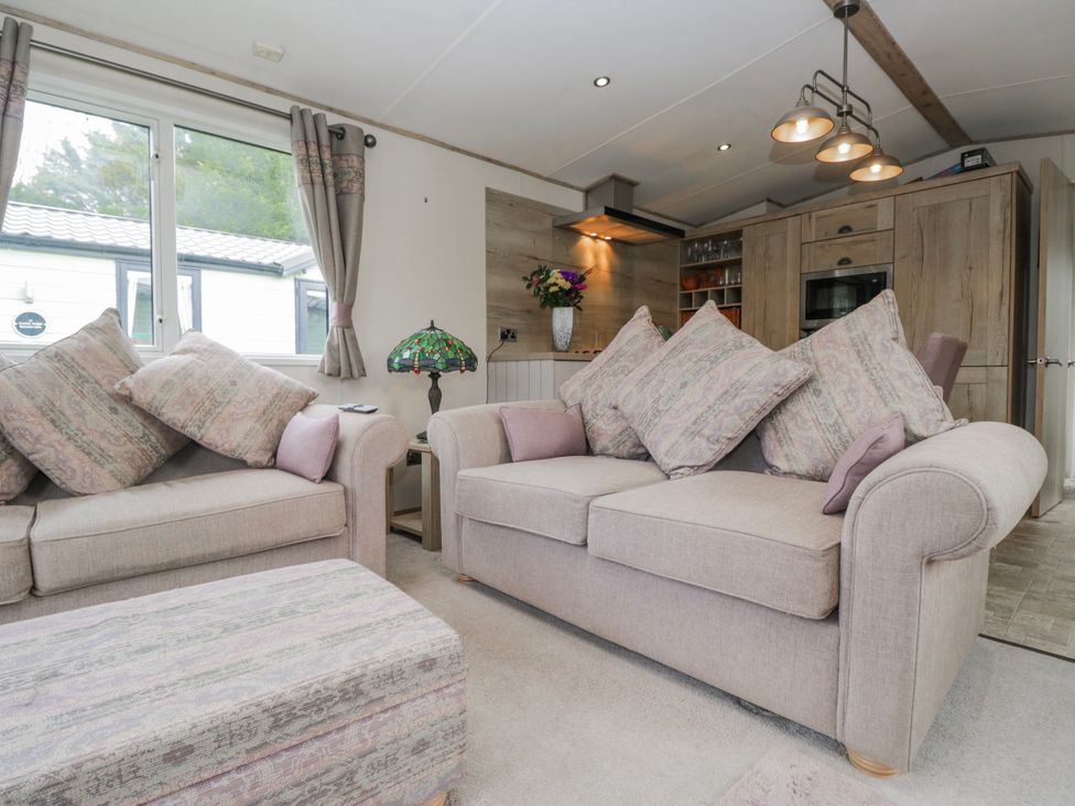 A living room with sofas and a flower vase at Carp Lodge