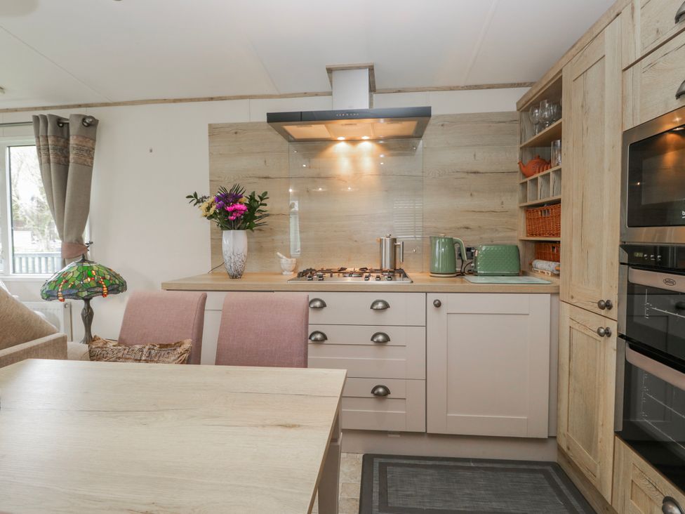 A kitchen with a stove, oven, sink, and dining table at Carp Lodge