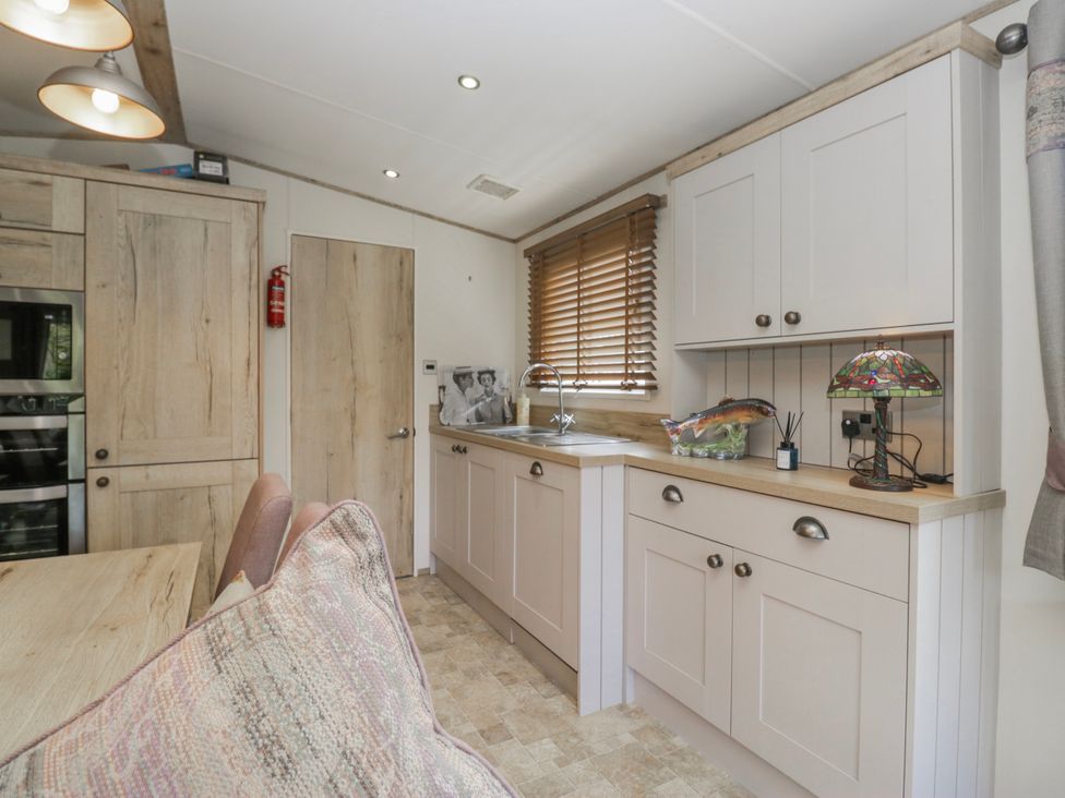 A kitchen with cabinets and a sink at Carp Lodge