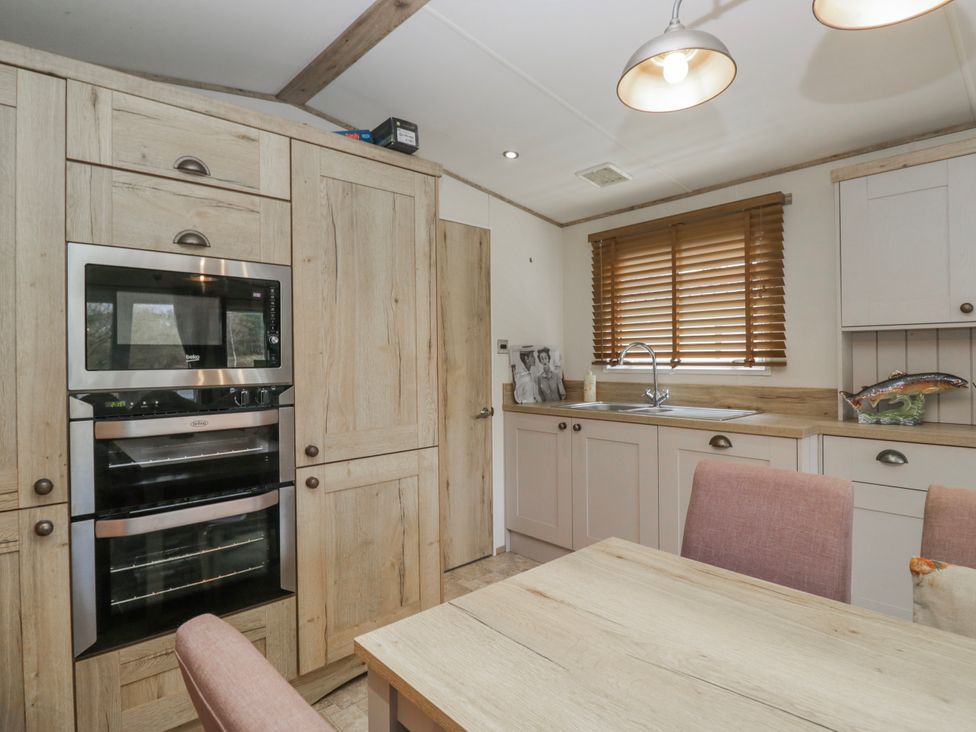A kitchen with cabinets and appliances at Carp Lodge