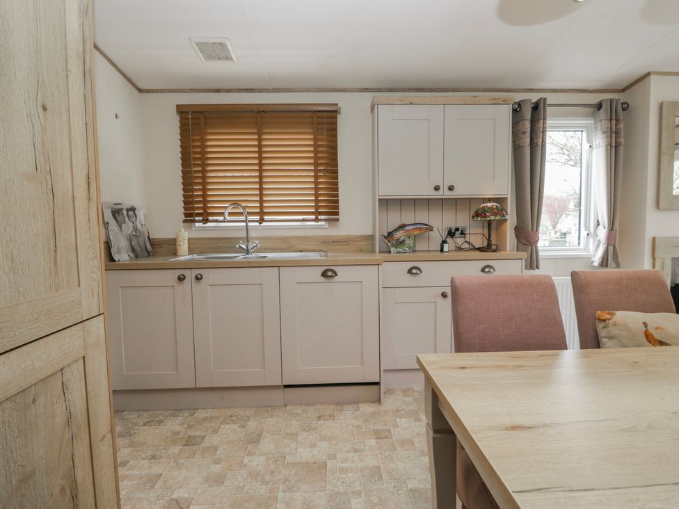 A kitchen with cabinets and a sink at Carp Lodge