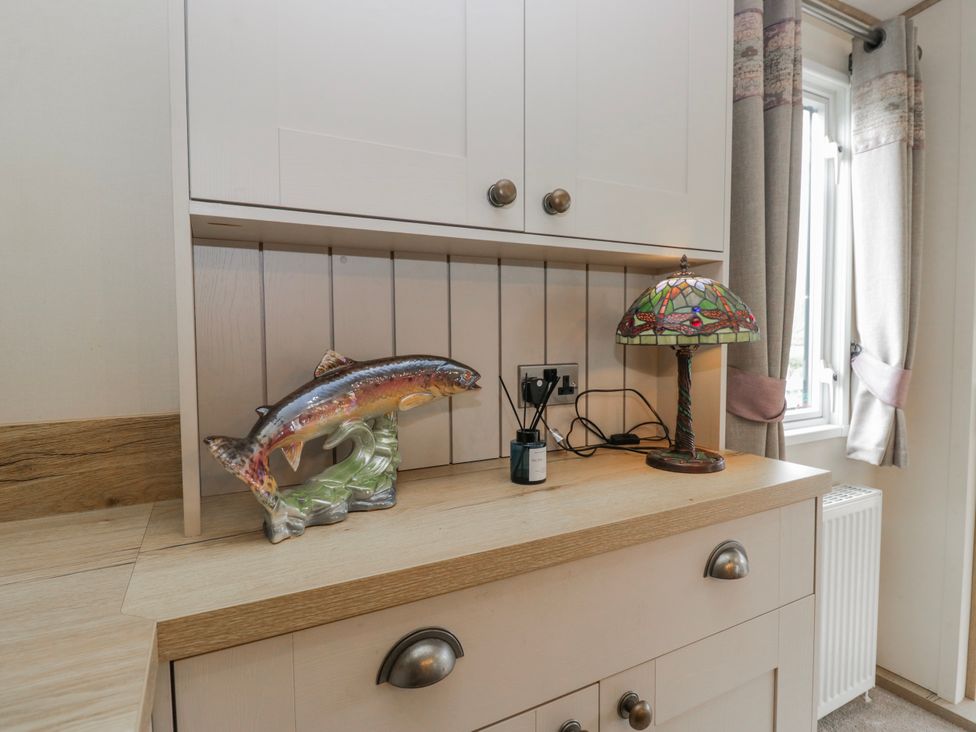 A kitchen countertop with a fish figurine and a lamp at Carp Lodge