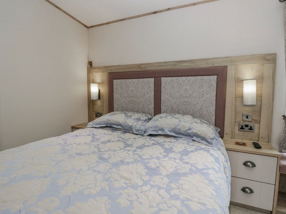 A bedroom with a bed and nightstand at Carp Lodge