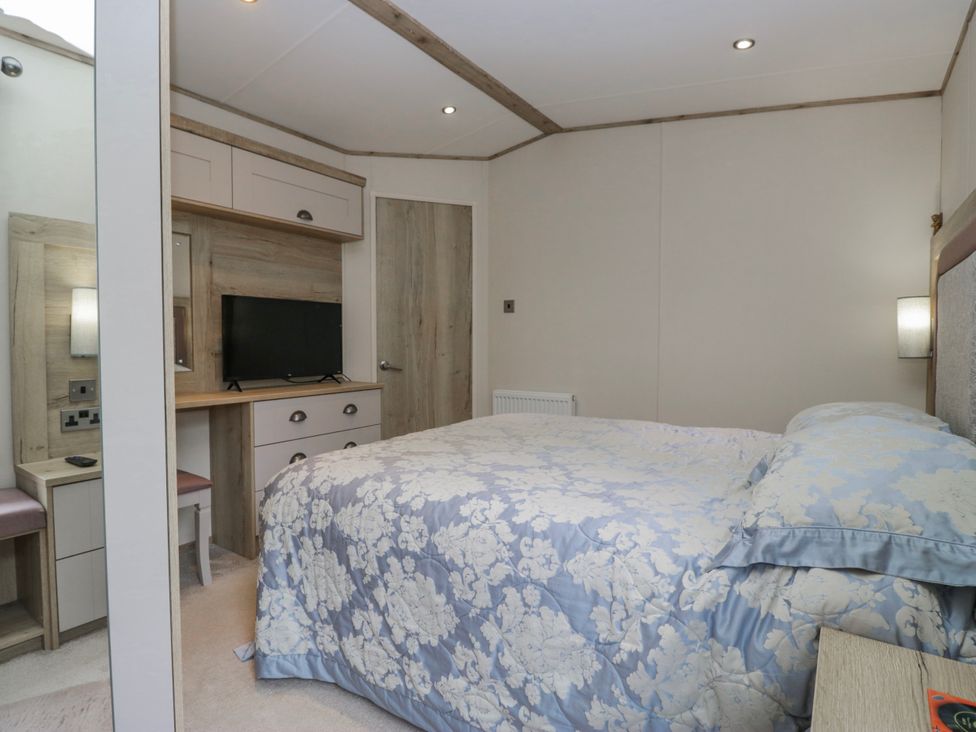 A bedroom with a bed and television at Carp Lodge