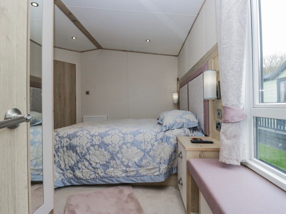 A bedroom with a bed and bedside table at Carp Lodge
