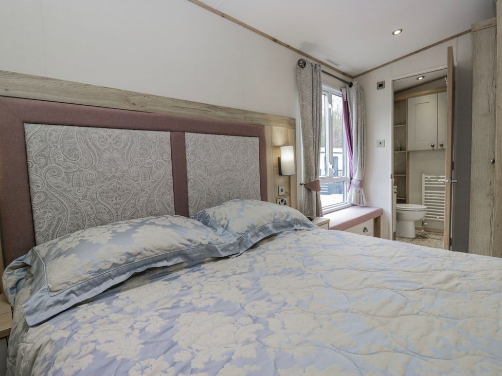 A bedroom with a bed and window at Carp Lodge