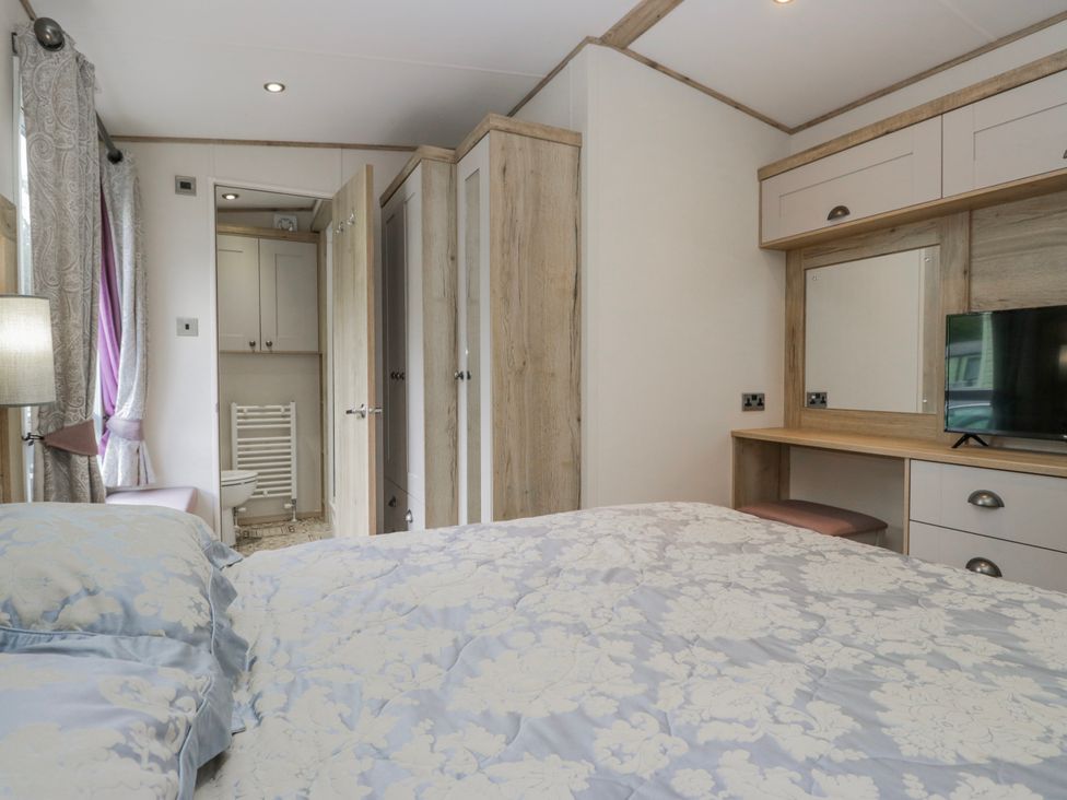 A bedroom with a bed and a television at Carp Lodge