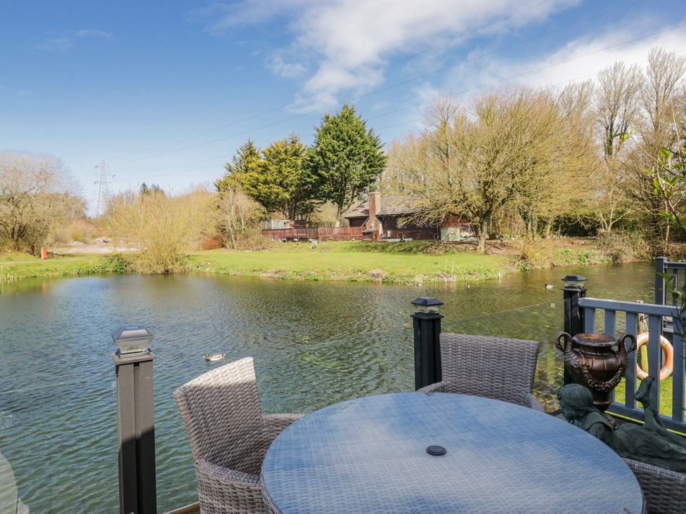 A view of a lake with trees and a house at Carp Lodge