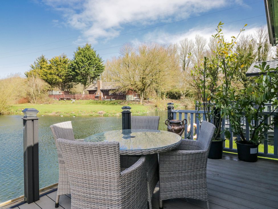 An outdoor seating area by a water body at Carp Lodge