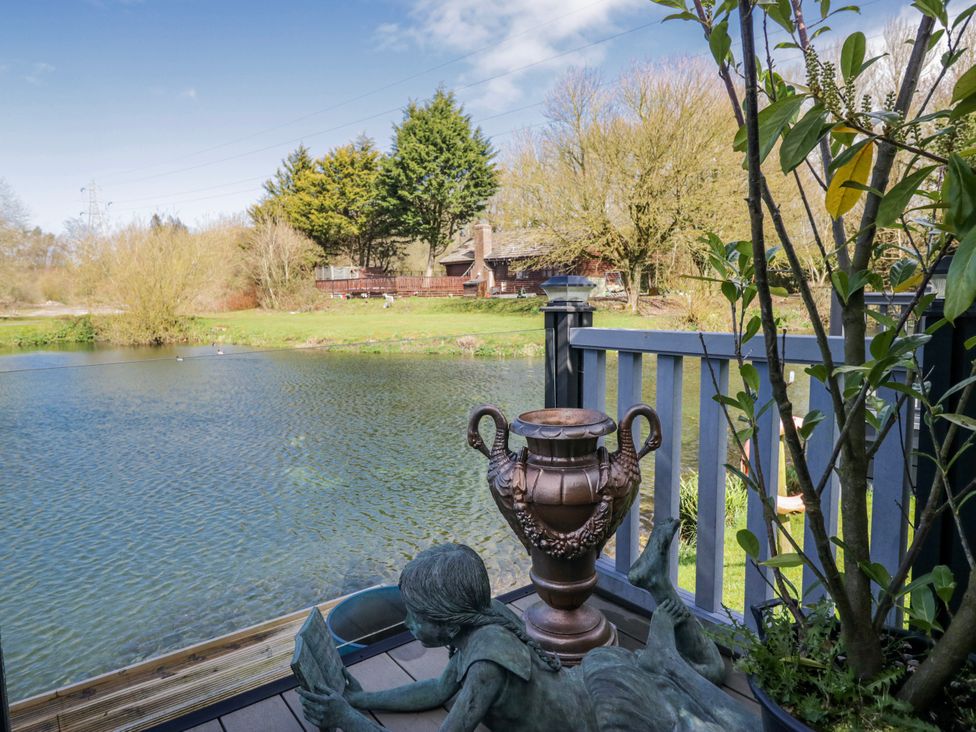A pond with a statue and a planter at Carp Lodge