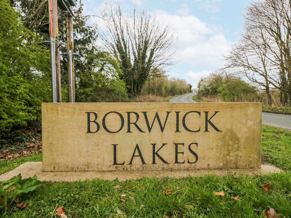 A sign for Borwick Lakes beside a road