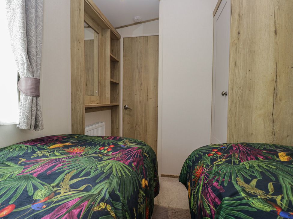 A bedroom with two beds and a mirror at Carp Lodge near Carnforth