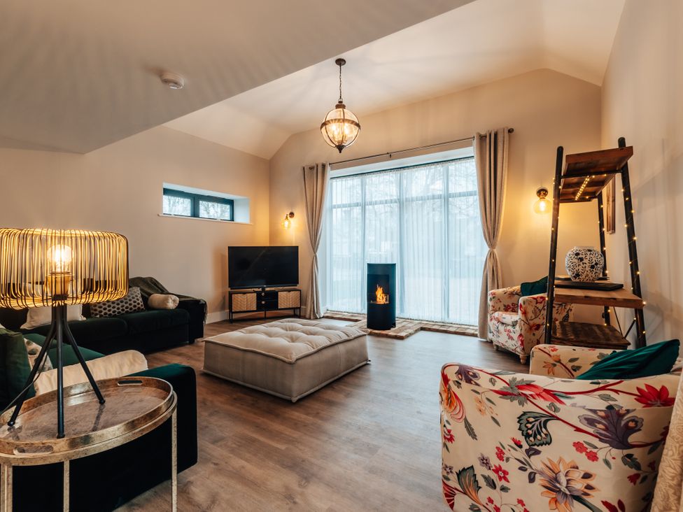 A living room with a TV and sofa at The Stables in Catworth