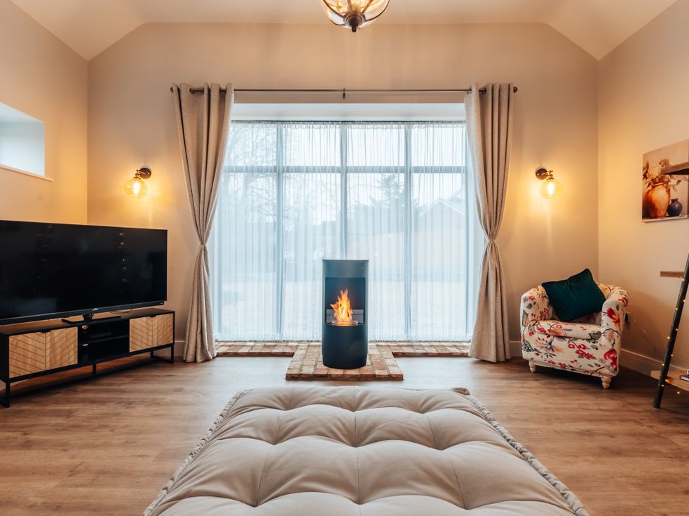 A living room with a TV and a fireplace at The Stables in Catworth
