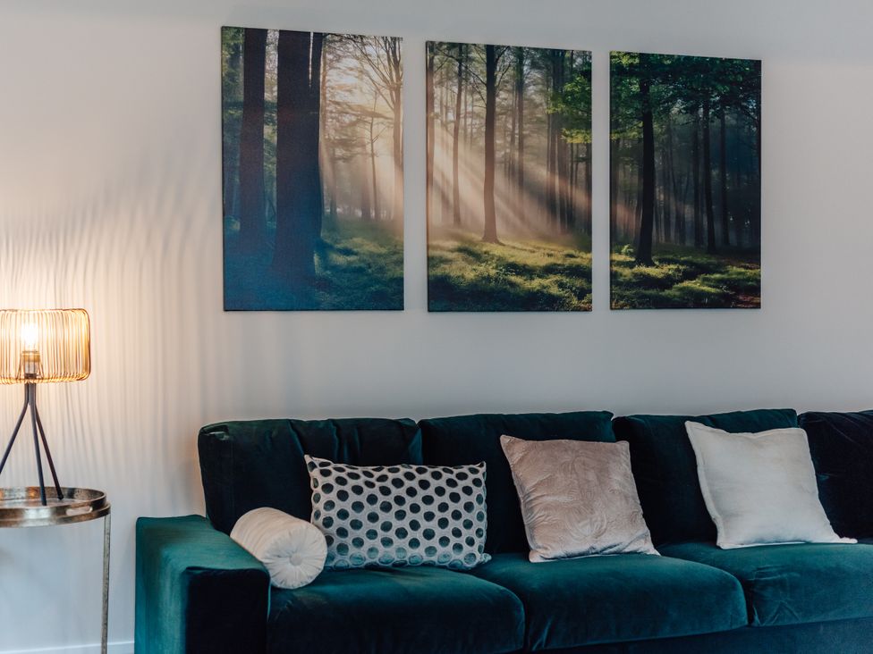 A living room with wall art, sofa and cushions at The Stables in Catworth