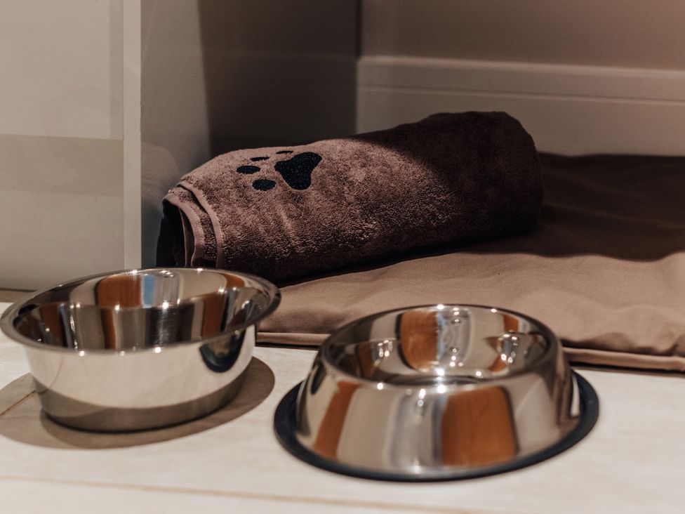 A pet area with bowls and a towel at The Stables in Catworth