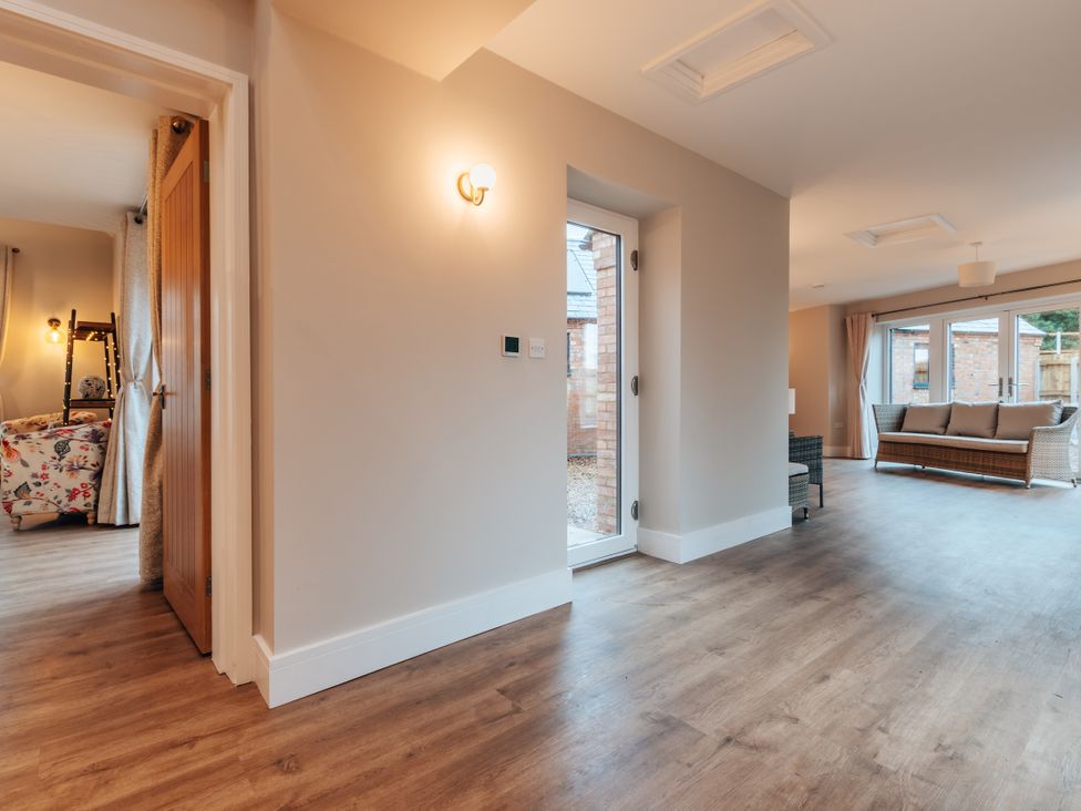 A living room with a sofa and door leading outside at The Stables in Catworth