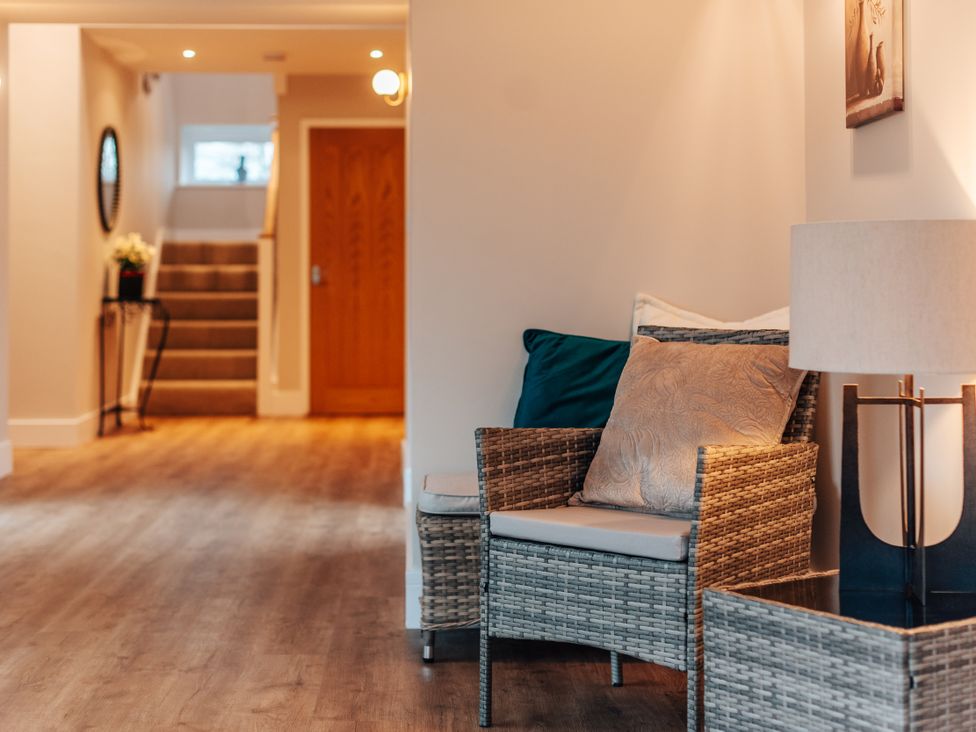 A hallway with a chair and lamp at The Stables in Catworth