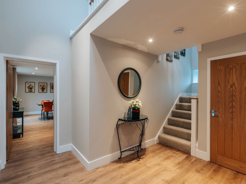 A hallway with a staircase and a console table at The Stables in Catworth