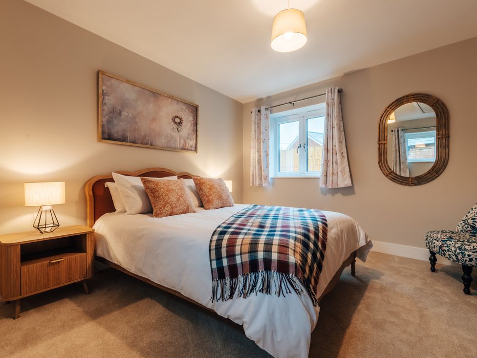 A bedroom with a bed and lamp at The Stables in Catworth