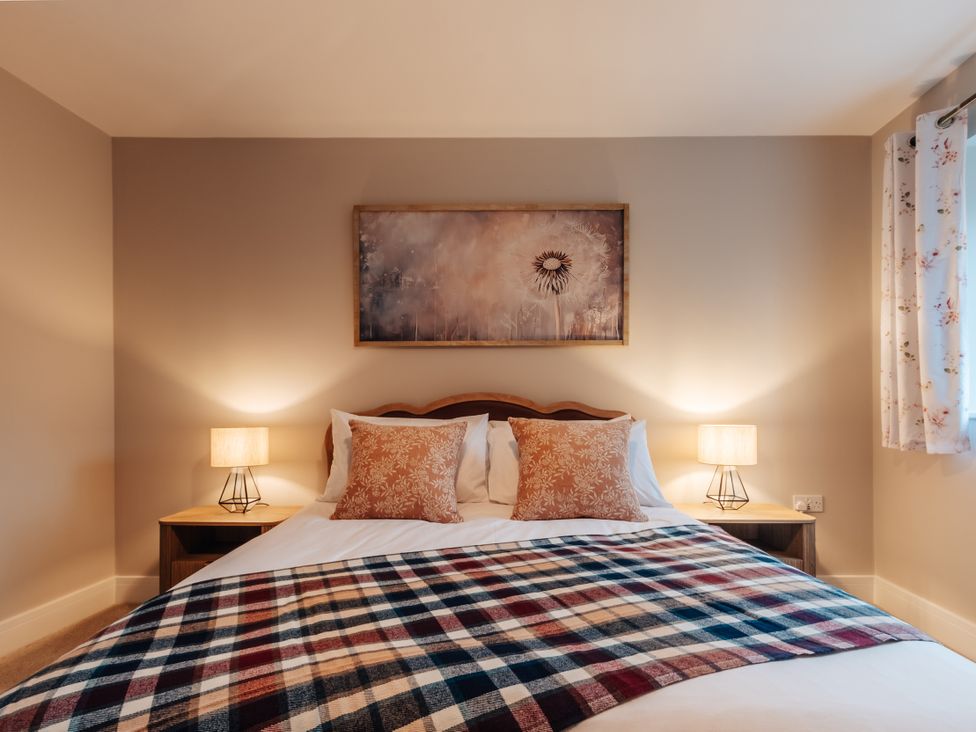 A bedroom with a bed and lamps at The Stables in Catworth