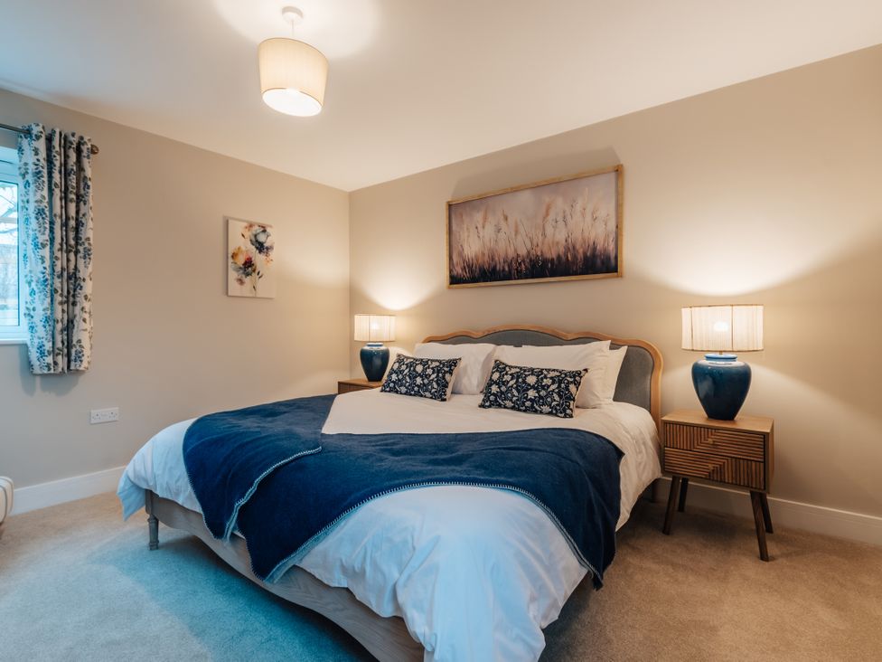 A bedroom with a bed and bedside tables at The Stables in Catworth