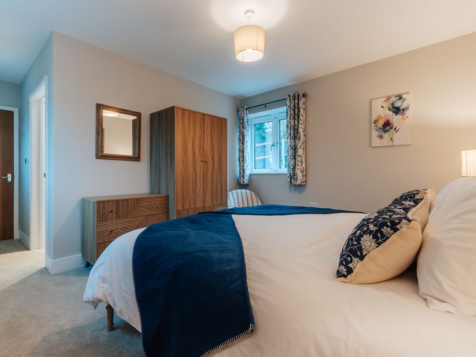 A bedroom with a bed and wardrobe at The Stables in Catworth