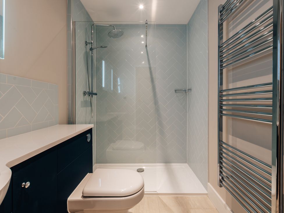 A bathroom with a shower, toilet, and sink at The Stables in Catworth