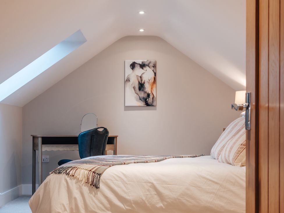 A bedroom with a bed and desk at The Stables in Catworth