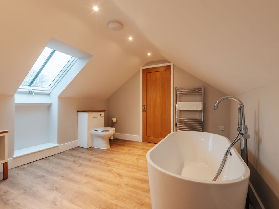 A bathroom with a bathtub and toilet at The Stables in Catworth