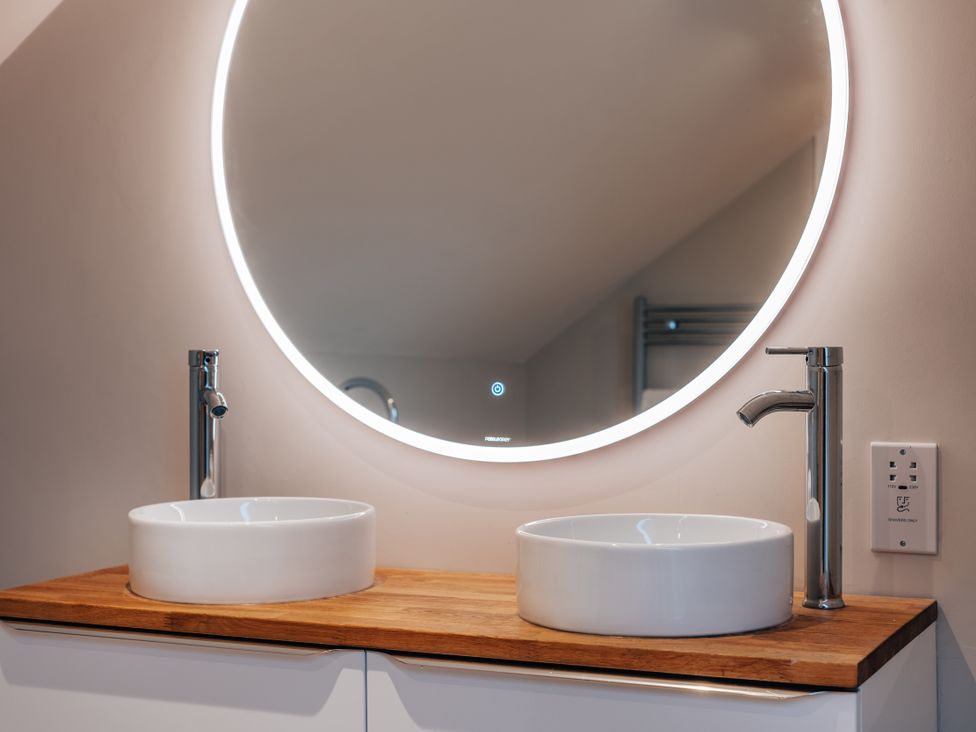 A bathroom with two sinks and a large mirror at The Stables in Catworth