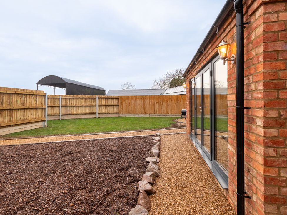 A garden area with gravel path and grass at The Stables in Catworth