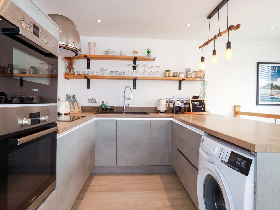 A kitchen with appliances and shelves at La Casita in Newquay