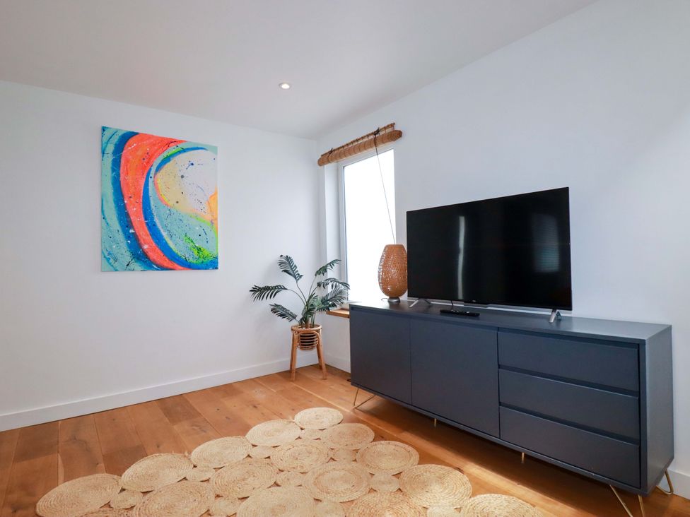 A living room with a television and sideboard at La Casita in Newquay
