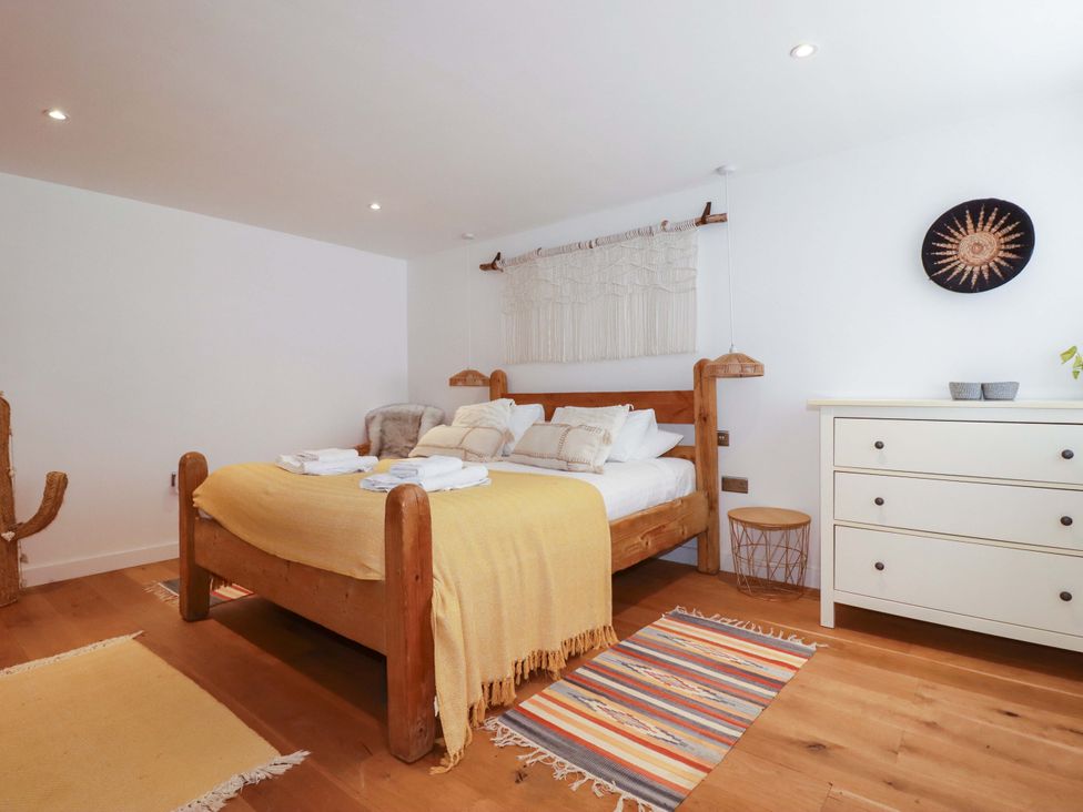 A bedroom with a bed and dresser at La Casita in Newquay