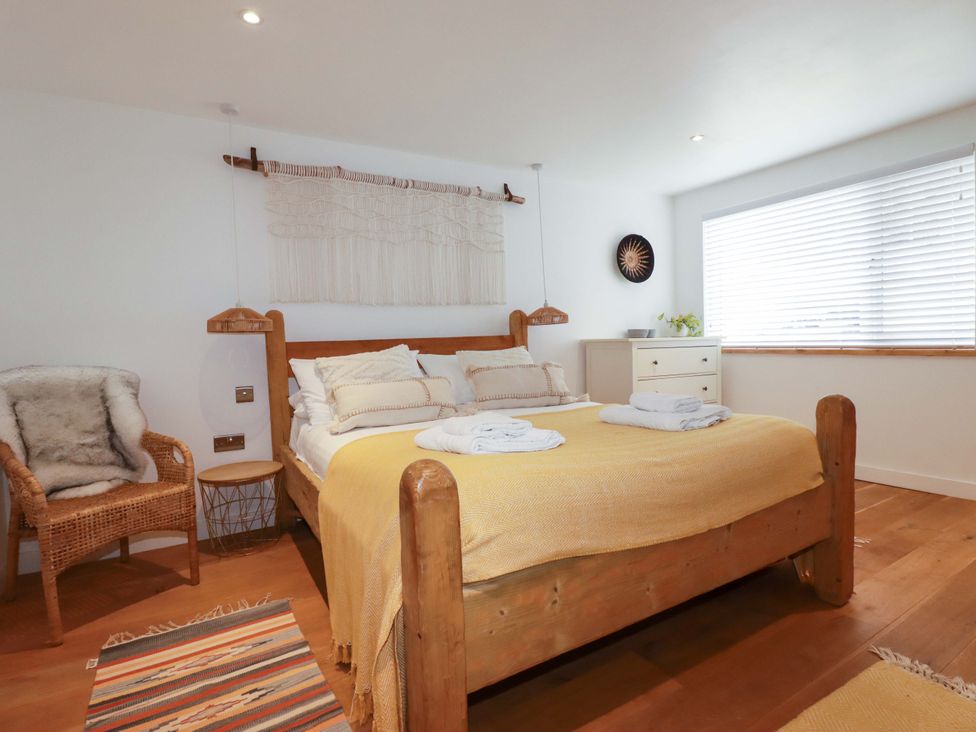 A bedroom with a bed and chair at La Casita in Newquay