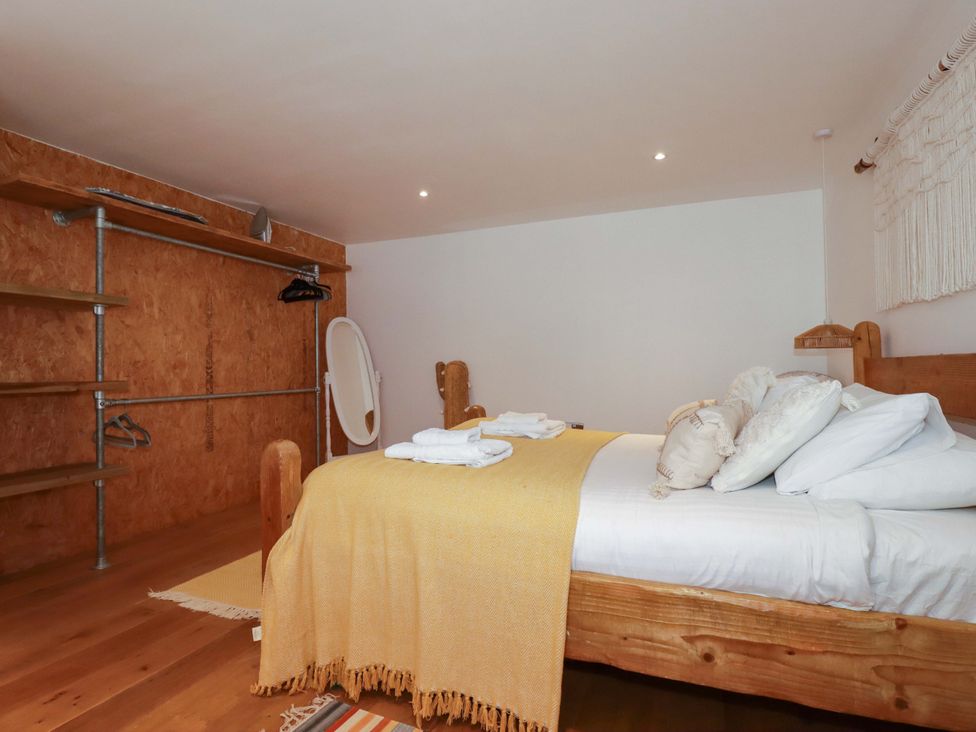 A bedroom with a bed and shelving unit at La Casita in Newquay