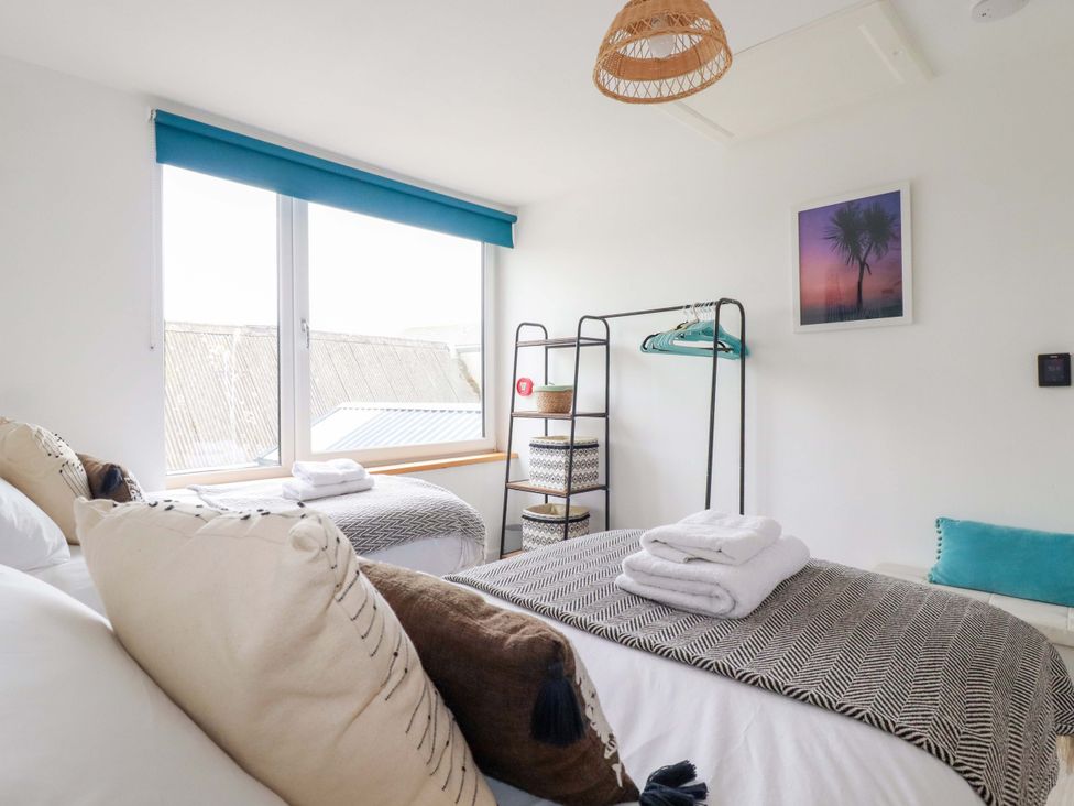 A bedroom with two beds and a window at La Casita in Newquay