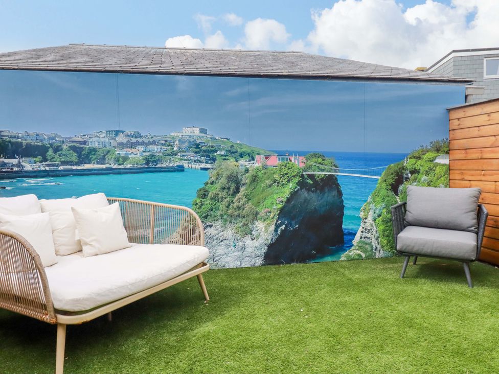 A garden with seating and a mural view at La Casita in Newquay