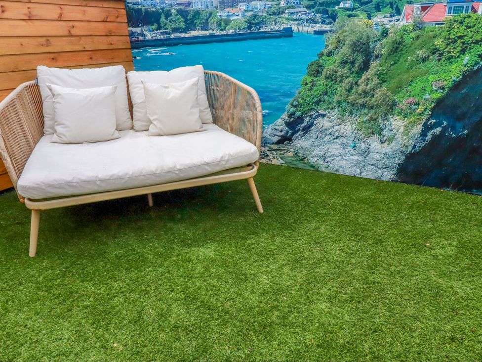 A couch with pillows on artificial grass in La Casita Newquay