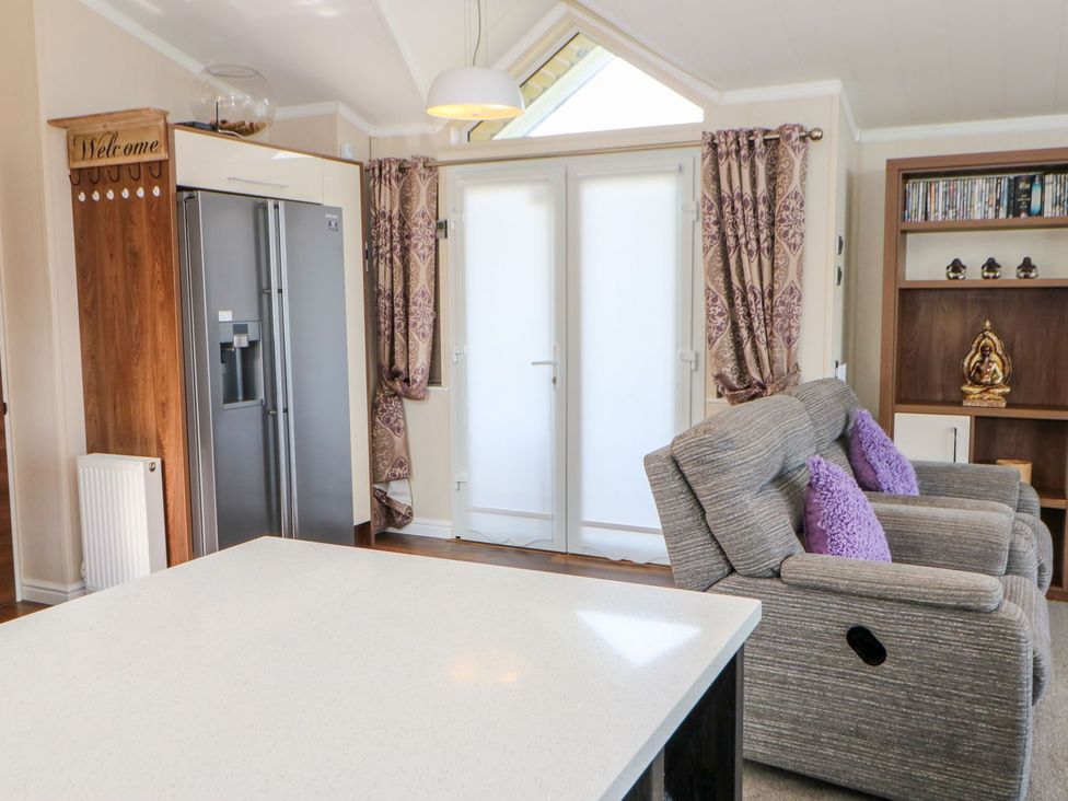 A living room with a refrigerator and sofa at 37 Horizon Park in Hartlepool