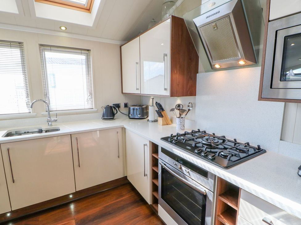A kitchen with a gas stove and kitchen cabinets at 37 Horizon Park in Hartlepool