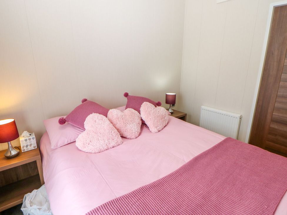 A bedroom with a bed and heart-shaped pillows at 37 Horizon Park in Hartlepool