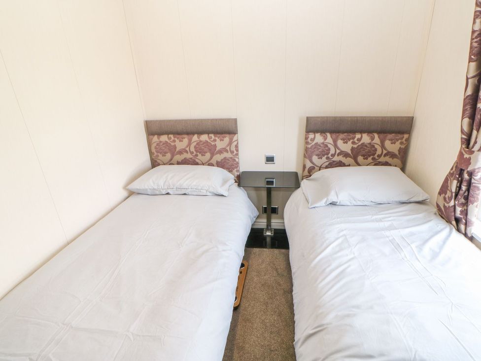 A bedroom with two single beds and a bedside table at 37 Horizon Park Hartlepool